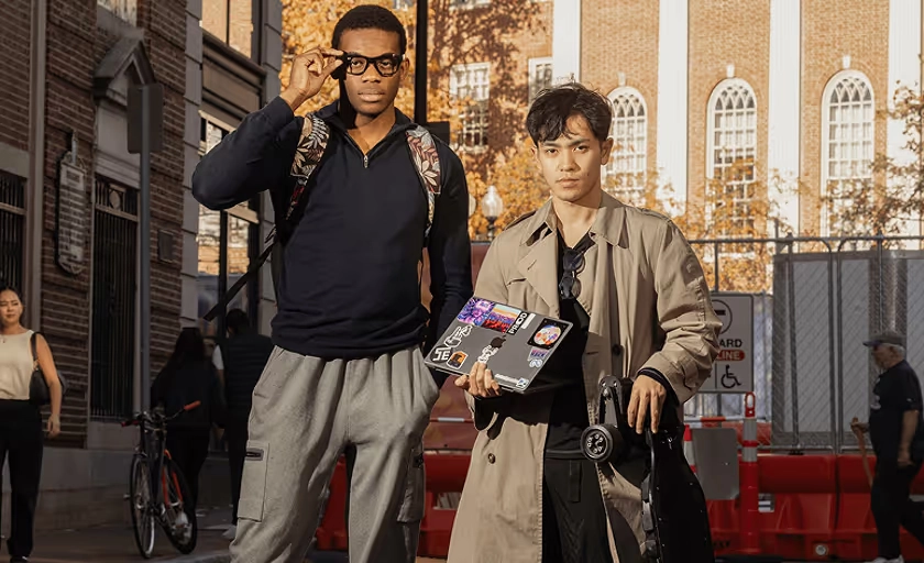 Two men in glasses standing together on a city street